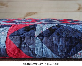 Folded Blue And Red Patchwork Quilt With Hand Quilting