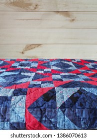 Folded Blue And Red Patchwork Quilt With Hand Quilting