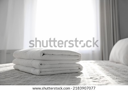 Folded clean blanket on bed in room
