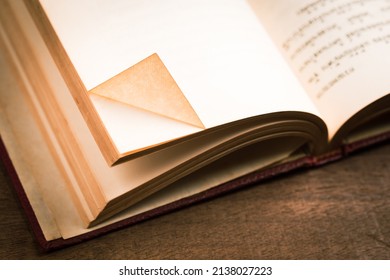 Folded corner of the current page (dog ear) as a bookmark in the paperback antique book - Powered by Shutterstock