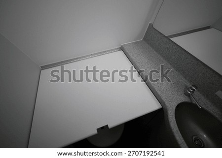 Folded down baby changing table inside an airplane lavatory.