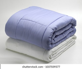 folded duvets or quilts. neutral background