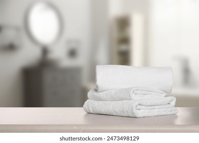 Folded fresh towels on table in bathroom. Space for text