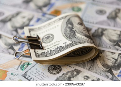 Folded in half stack of 100 dollar bills on the background of hundred dollar bills - Shutterstock ID 2309643287