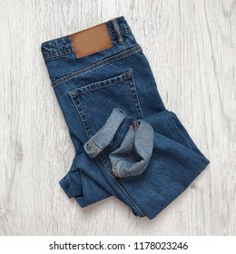 Folded jeans on a wooden background - Powered by Shutterstock