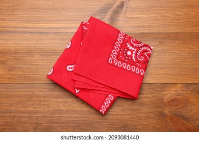 Folded Red Bandana With Paisley Pattern On Wooden Table, Top View