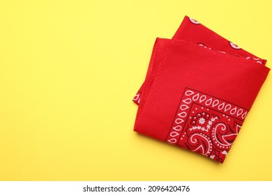 Folded Red Bandana With Paisley Pattern On Yellow Background, Top View. Space For Text