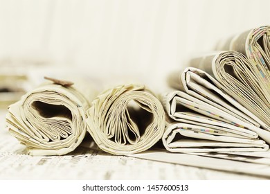 Falte und gedrehte Zeitungen auf dem Tisch. Viele Zeitschriften mit Nachrichten.                   
