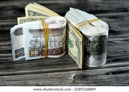 Folded stack Egypt money banknote bills of 100 and 50 EGP LE one hundred Egyptian and fifty Pounds on USA American dollars currency old vintage notes, Egyptian and United states currency exchange rate