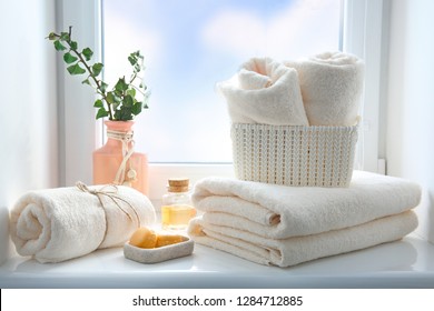 Folded Towels Stack,essential Oil And Soap On Window Sill Empty Copy Space.Body Care Concept,hotel Backdrop,bathroom Items.