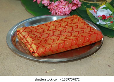 Folded Traditional Kerala Kasavu Saree And Red Silk Saree On A Dish During Indian Weddin