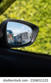 Folded Wing Mirror Of A Compact Modern Car, Seeing An Inner Car Door Handle. Car Parked In An Outdoor Natural Parking Lot During The Morning Time With Sun Rise.