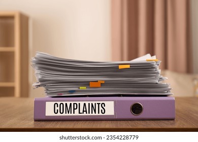 Folder with Complaints label and documents on office desk