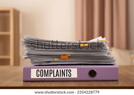 Folder with Complaints label and documents on office desk