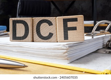 Folder and cubes with letters DCF Discounted Cash Flow.