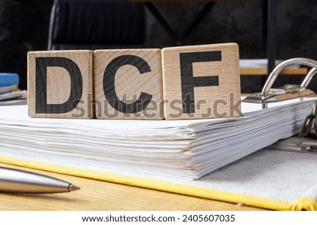 Folder and cubes with letters DCF Discounted Cash Flow.