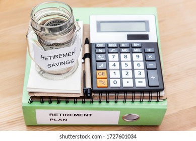 Folder With The Label Retirement Plan, money in glass with label retirement savings, notepad and calculator.