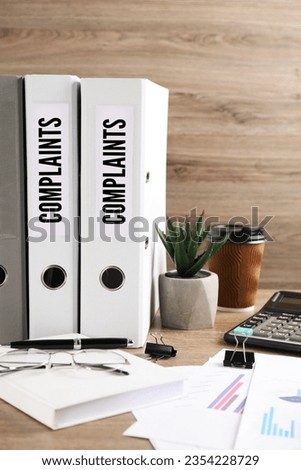 Folders with Complaints labels on office desk