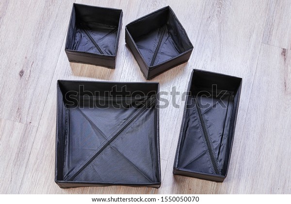 Folding boxes of black
color, of different sizes and shapes, are designed for separate
storage of garments in drawers, these containers are dividers for
storing clothes.