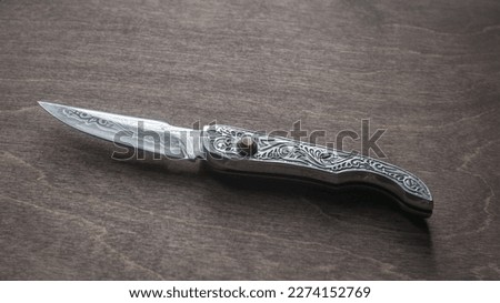 Folding button knife with engraving.