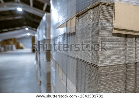 Folding cardboard boxes. Perforated sheets of corrugated cardboard a stack on pallets. Packaging of finished products in industrial production.