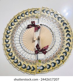 a folding fan made of money, a gift for a special day, a gift of money, a gift to one's parents, filial piety