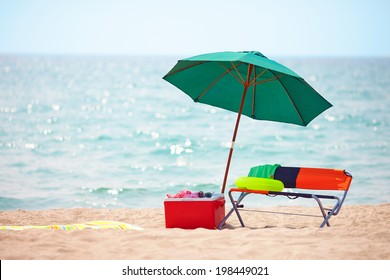 folding furniture and ice box on summer beach - Powered by Shutterstock