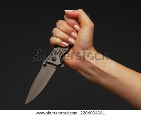 Folding knife in the hands of a woman. Close-up