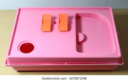 Folding Old And Empty White And Pink Hamster Cage On Wood Desk