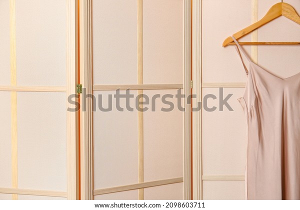 Folding screen with dress in\
room