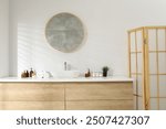 Folding screen and round mirror over sink in bathroom. Interior design