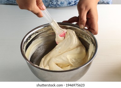 Folding Technique (Aduk Balik) Cream Batter On Stainless Bowl. Female Hand Chef Process Step By Step Baking Using Spatula