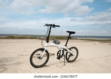 Folding White Bike On The Beach In Summer