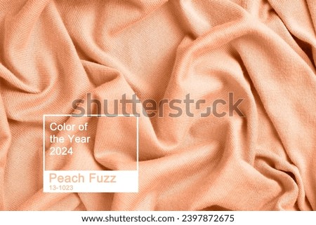 Folds of knitted clothes close-up, concept color of the year 2024 Peach Fuzz.