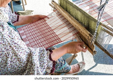 Folk Art Festival. A Woman Weaver Makes Fabric On A Hand Loom.