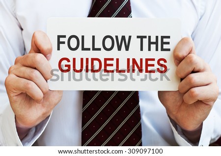 Follow the Guidelines. Man holding a card with a message text written on it