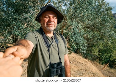 Follow me. Bearded man hold and pull the photographer's hand leading her on olive grove in the mountain. Concept of togetherness and carefree modern life, healthy lifestyle, sport and trekking. - Powered by Shutterstock