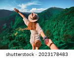 Follow me concept and traveling together. Girl traveler wearing hat, round straw bag and short jumpsuit holds the boyfriend