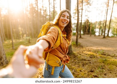 Follow me concept and traveling together. Happy woman holds the boyfriend's hand and walking on the forest. Vacation, tourism. Hiking. - Powered by Shutterstock