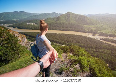 Follow me concept - Woman wanting her boyfriend to follow her in travel on the top of mountain in Altai