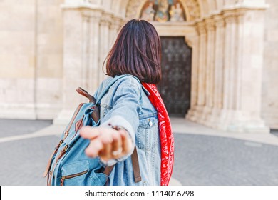 Follow Me To Matthias Church In Budapest. Mixed Race Woman Traveler With Backpack Heading To Tourist Sights And Destinations In Europe