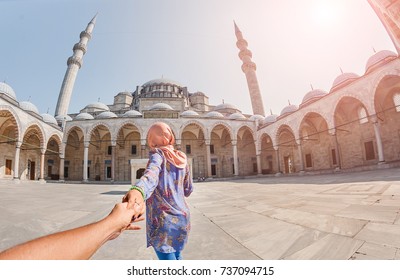 Follow Me. A Muslim Woman In A Scarf Leads Her Friend To The Turkish Mosque Suleymaniye, Travel And Religion Concept.