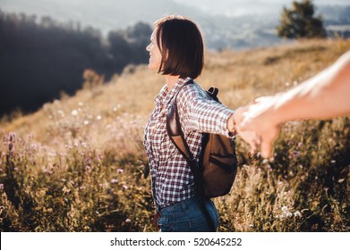 Follow Me Picture With Focus On Girl. Traveler Woman Holding Man's Hand And Leading Him On Nature Outdoor. Vintage Toned Picture With Instagram Filter