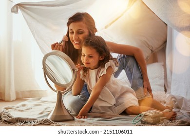 Follow my lead. Shot of a mother and daughter having fun and playing around with makeup. - Powered by Shutterstock