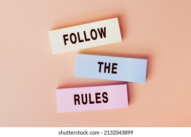 Follow The Rules. Concept of text on color cards. Top view image of cards and on pastel beige background. Flat lay design