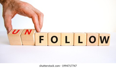 Follow or unfollow symbol. Businessman turns wooden cubes and changes words follow to unfollow. Beautiful white background, copy space. Business and follow or unfollow concept.