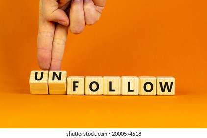 Follow or unfollow symbol. Businessman turns wooden cubes and changes words follow to unfollow. Beautiful orange background, copy space. Business and follow or unfollow concept.