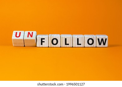 Follow or unfollow symbol. Turned wooden cubes and changed words follow to unfollow. Beautiful orange background, copy space. Business and follow or unfollow concept.