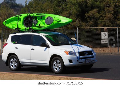 FOLSOM, CA, USA - SEP 18, 2017: Lake Natoma, SUV Carrying A Water Craft. Sacramento State University Aquatic Center. Active Lifestyle Sport Concept. Car With Kayak Green On Top Roof. 