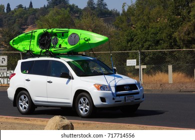 FOLSOM, CA, USA - SEP 18, 2017: Lake Natoma, SUV Carrying A Water Craft. Sacramento State University Aquatic Center. Active Lifestyle Sport Concept. Car With Kayak Green On Top Roof. 